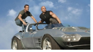 Dom and Brian get ready to jump off a car
